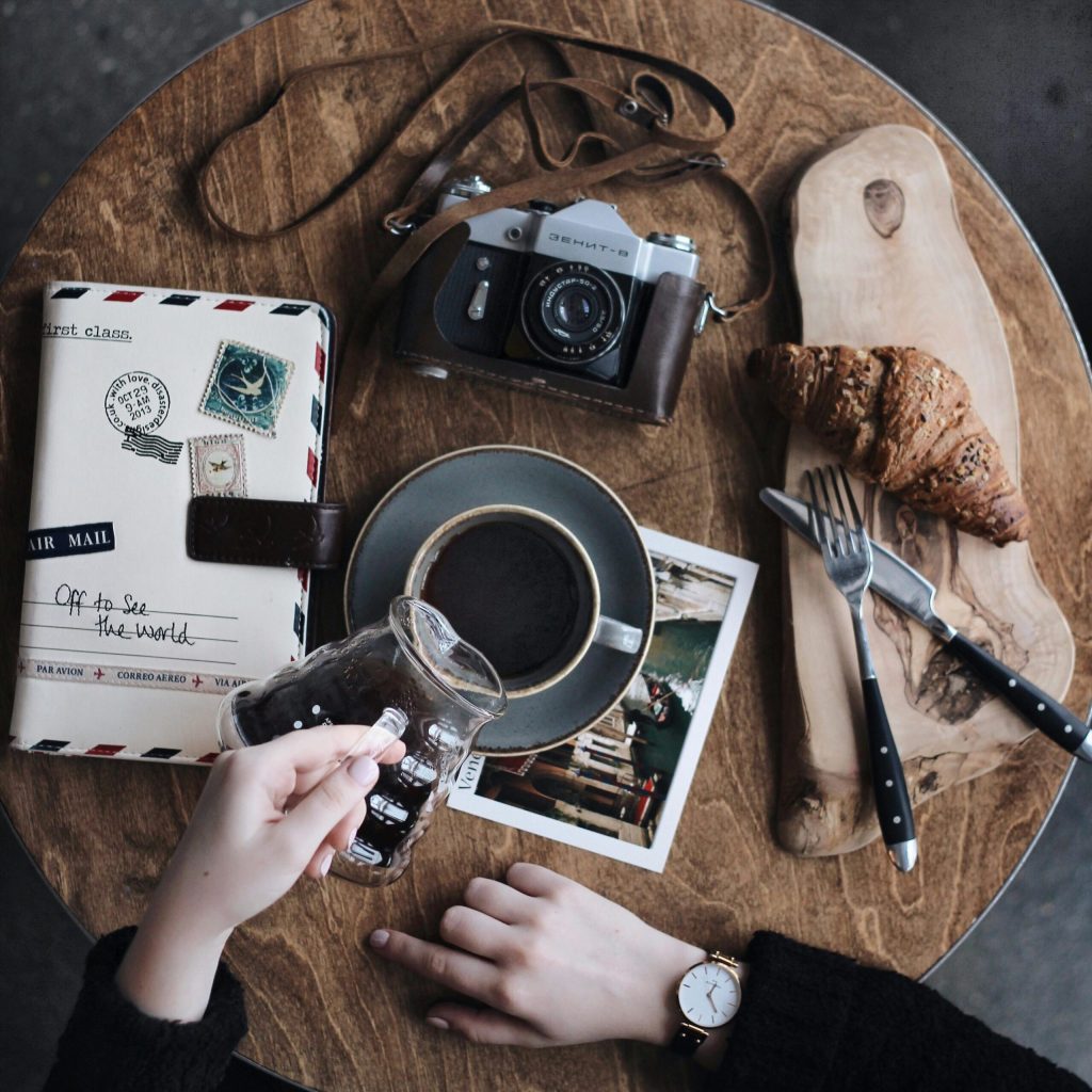 Baked Bread on Brown Wooden Surface Beside Grey Point-and-shoot Camera on Table